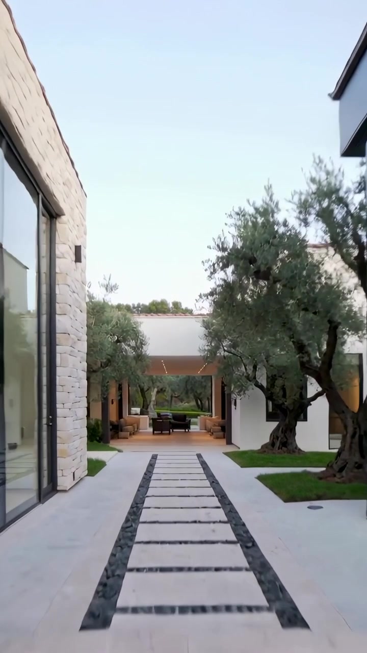 Video verticale: Telecamera in movimento che mostra un arco alto con profilo LED, una soglia e una pergola in un cortile.