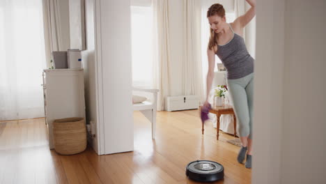 mujer feliz bailando en casa con una aspiradora robot haciendo tareas celebrando con bailes divertidos divirtiéndose limpiando la casa 4k