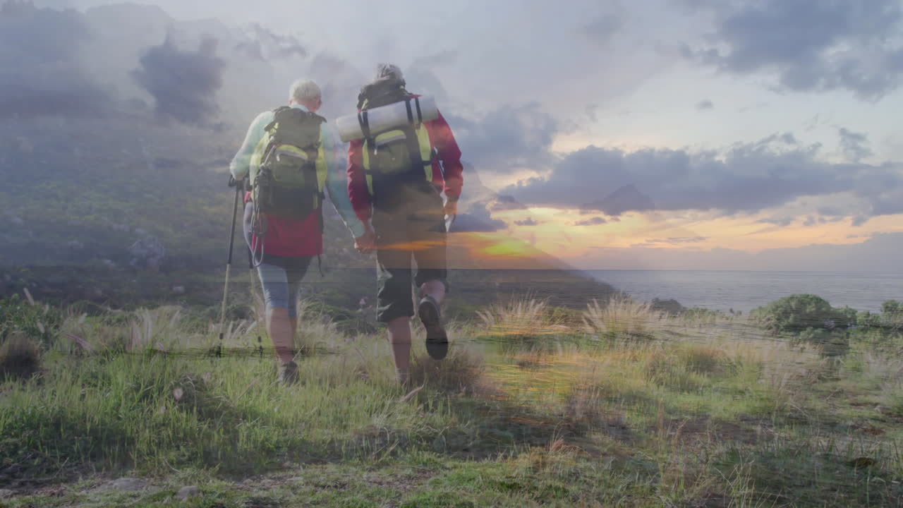 Hikers climbing coastal hill at sunset for travel marketing, with animated route line