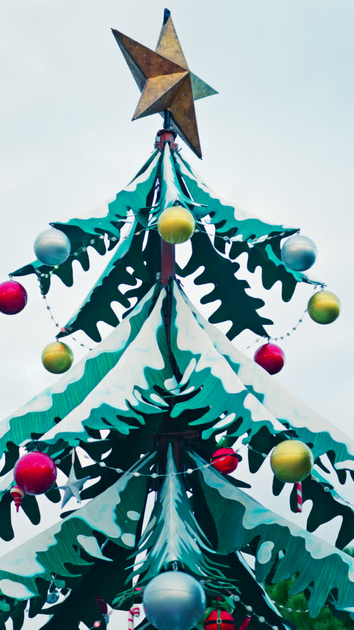 Close up of decorations on a metal rotating Christmas tree. Vertical
