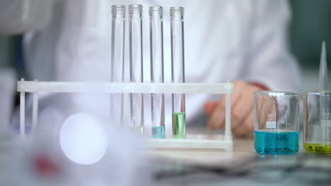 Chemist-put-liquids-in-test-tubes-on-table-with-pipette