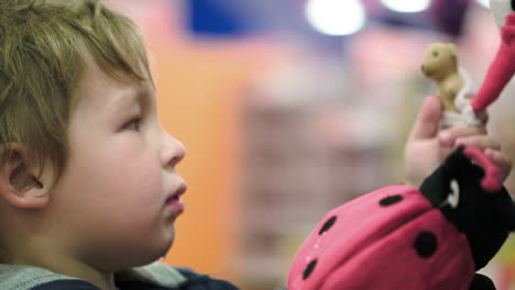 little child choosing soft toys in the shop