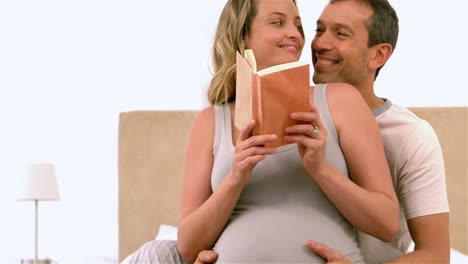 futuros padres felices leyendo un libro