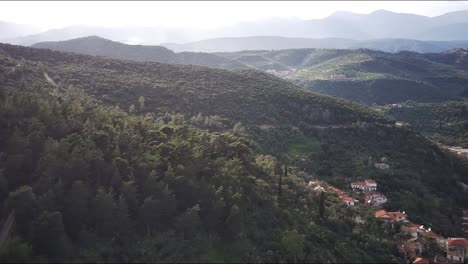 Eine-Luftaufnahme-Der-Stadt-Gythio-In-Griechenland-Mit-Kleinen-Häusern-Und-Gebäuden-Und-Bergen-Im-Hintergrund