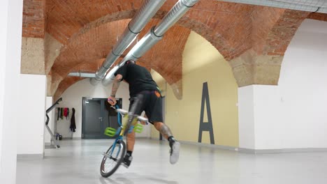 bmx bike rider playing around inside of a warehouse