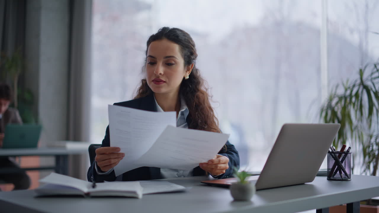 Woman professional working office texting laptop taking report documents closeup