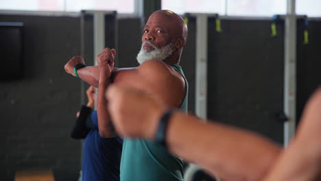 grupo de personas estirándose en un gimnasio