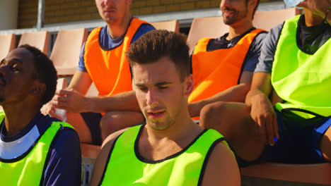 tired soccer players sitting in the stadium 4k