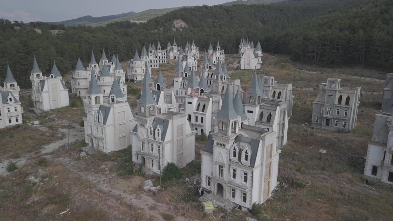 4K 10-bit nærbillede drone-orbitoptagelse, der roterer omkring forladte Disney-inspirerede borgspir i spøgelsesbyen Burj Al Babas, Tyrkiet.