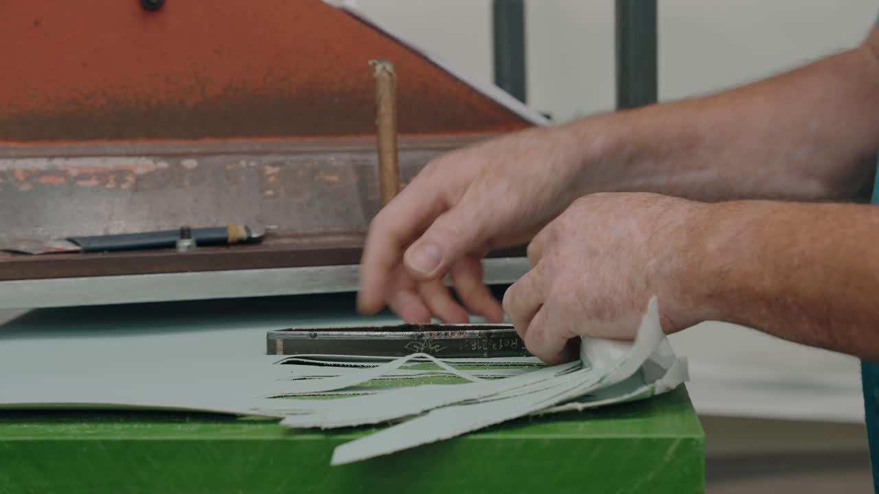 신발 가죽 조각을 재단하는 기계를 작동하는 작업자의 클로즈업