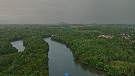 Pedregal-Panamá-Vista-Aérea-V1-Panorámica-Volar-A-Baja-Altura-Alrededor-Del-Río-Platanal-Capturando-La-Ciudad-Portuaria-Y-La-Densa-Vegetación-Con-El-Cielo-Cubierto-De-Nubes-Tormentosas---Rodada-Con-Cine-Mavic-3---Abril-De-2022