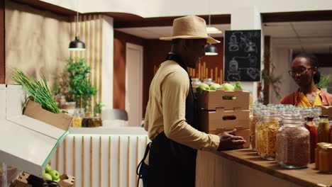 local vendor placing crates with freshly harvested fruits on grocery store