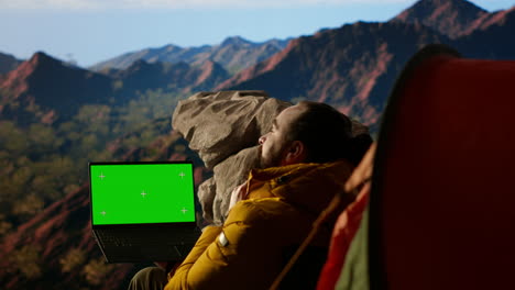 young traveler embraces high altitude wilderness next to chroma key