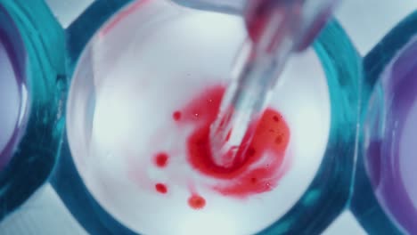 drawing out blood with pipette from glass container in lab
