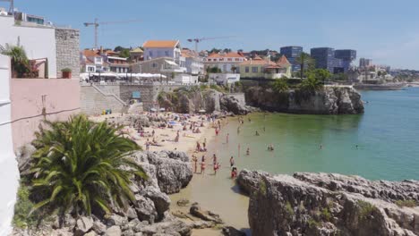 Una-Cálida-Escena-De-Verano-De-La-Playa-De-Rainha-En-Cascais,-Portugal,-Llena-De-Gente