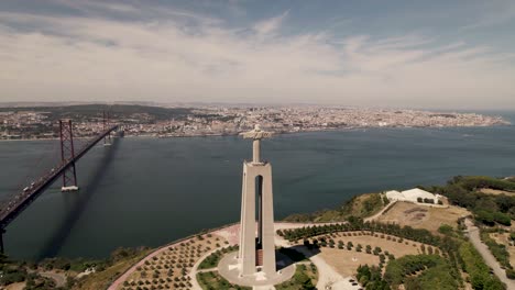 drone forward moving toward lisbon city capturing the statue of cristo rei and ponte 25 de abril