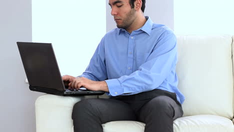 Portrait-of-a-businessman-using-a-laptop-on-a-couch