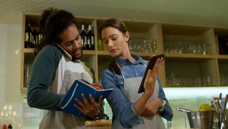 waiters taking orders on mobile phone and digital laptop 4k