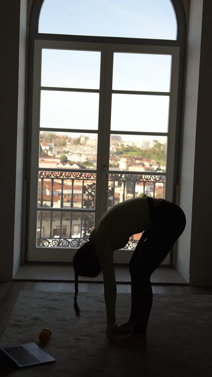 mujer haciendo estiramientos de yoga en casa