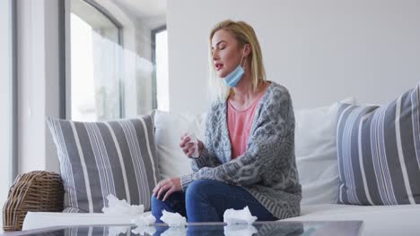 Sick-woman-holding-tissues-sitting-on-the-couch-at-home