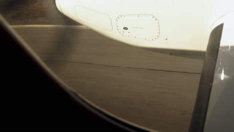 vista a través de la ventana de un avión de hélice que aterriza en la pista