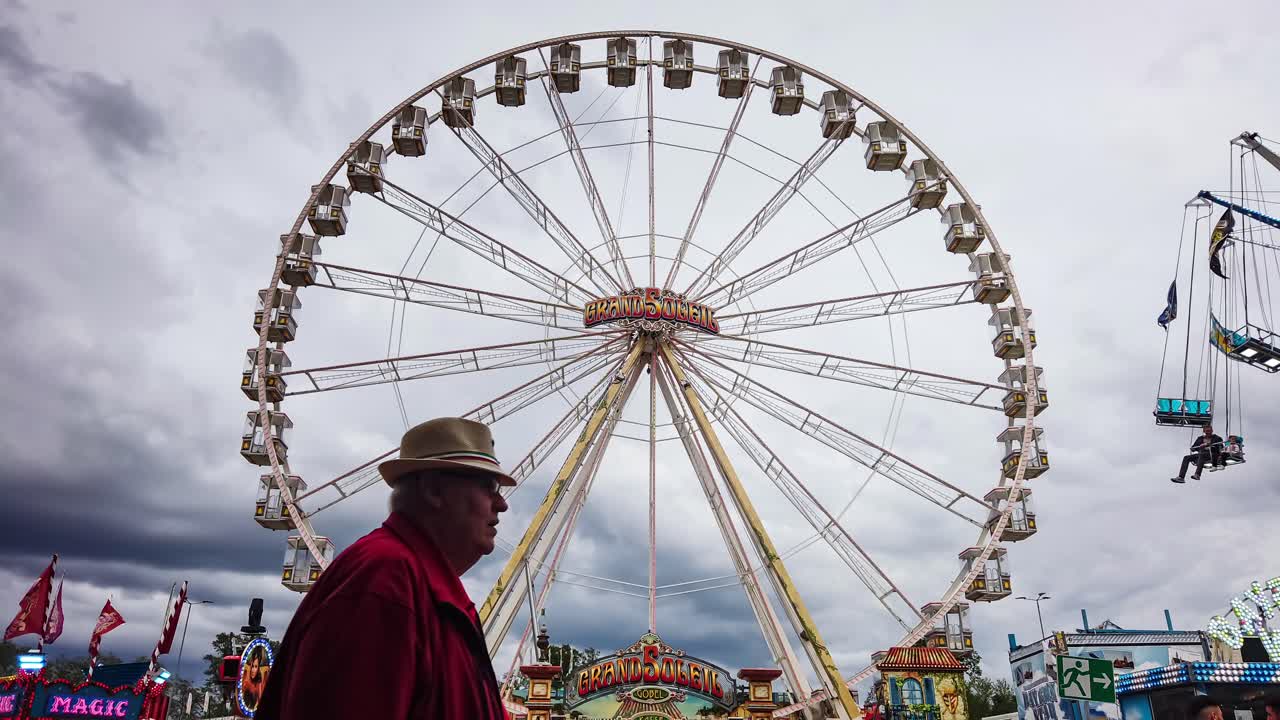 Overcast clouds of impending Storm forming over funfair rides, Time lapse