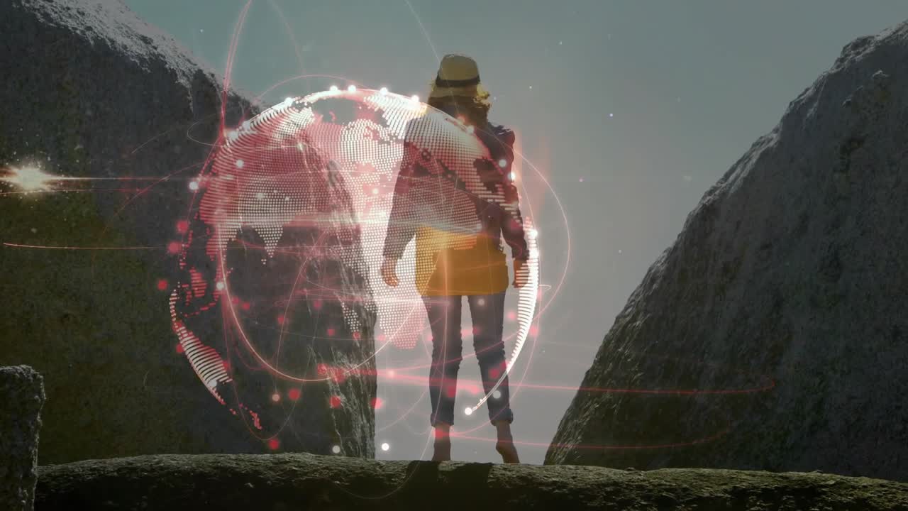 Donna in piedi sul bordo di un canyon mentre un globo olografico appare e anelli orbitanti in una demo tecnologica.