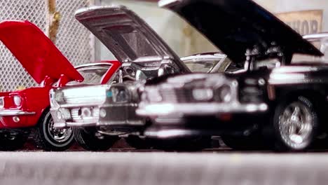 miniature mustang models on display with hoods open, captured from a low angle