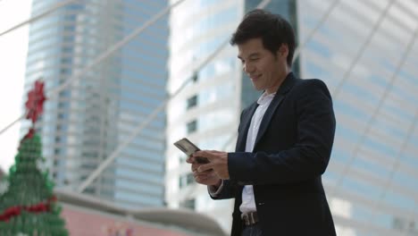 asian man using mobile phones to send text messages.