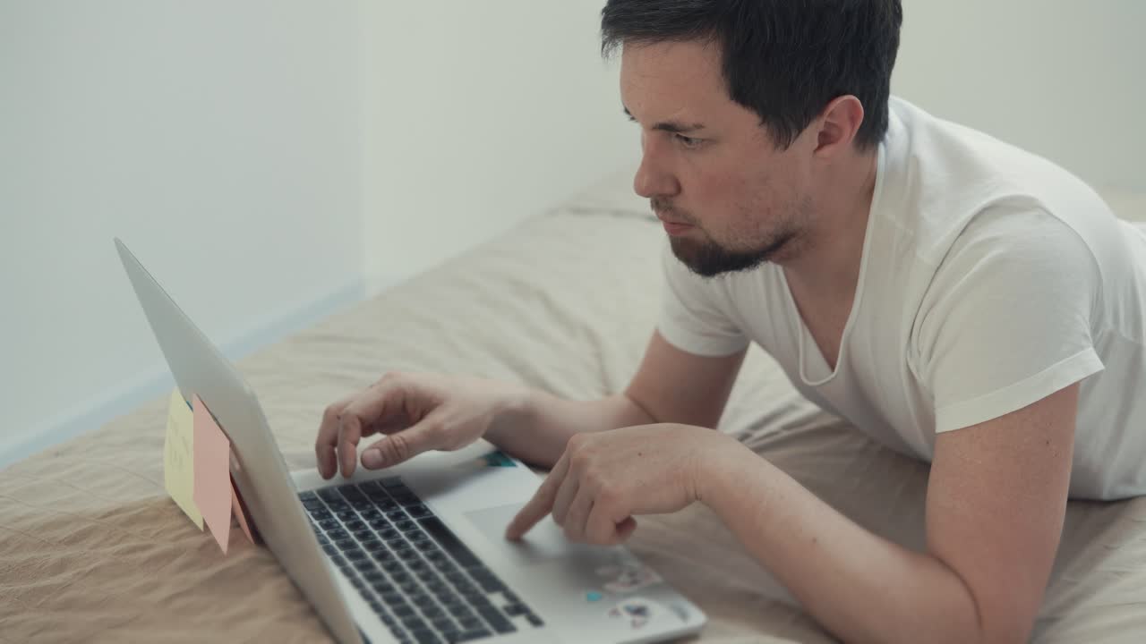 hombre trabajando en la computadora portátil en la cama