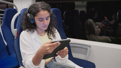 joven en un tren leyendo en una tableta