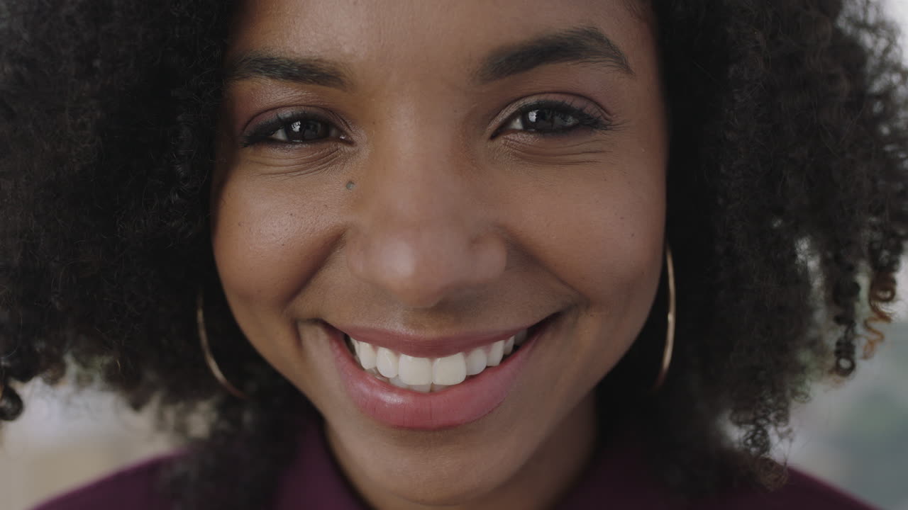 retrato em close-up de amigável jovem afro-americana mulher de negócios sorrindo alegremente olhando para a câmera desfrutando de um estilo de vida bem sucedido