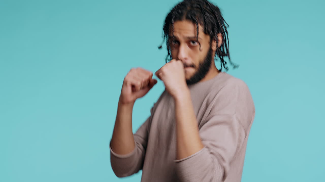 hombre lanzando puñetazos, sosteniendo la guardia defensiva, fondo del estudio