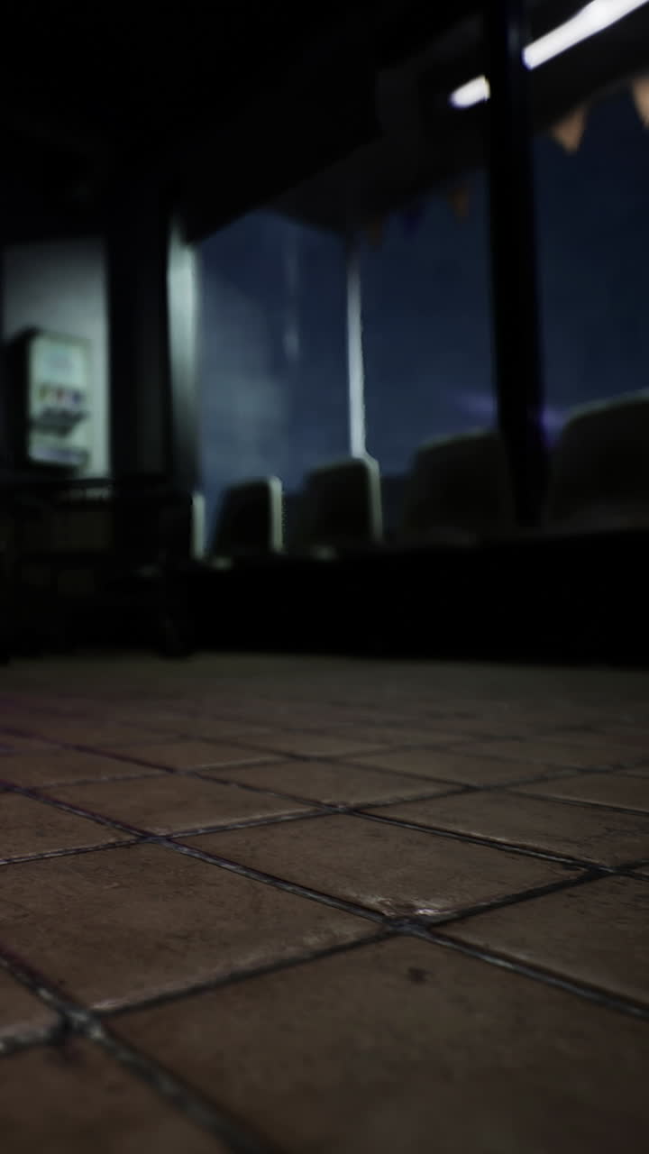 Light shines on a tiled floor in an empty waiting area at night