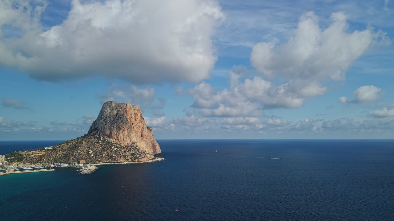 Peñón de Ifach con mar abierto y nubes dramáticas, vista aérea, Calpe, España