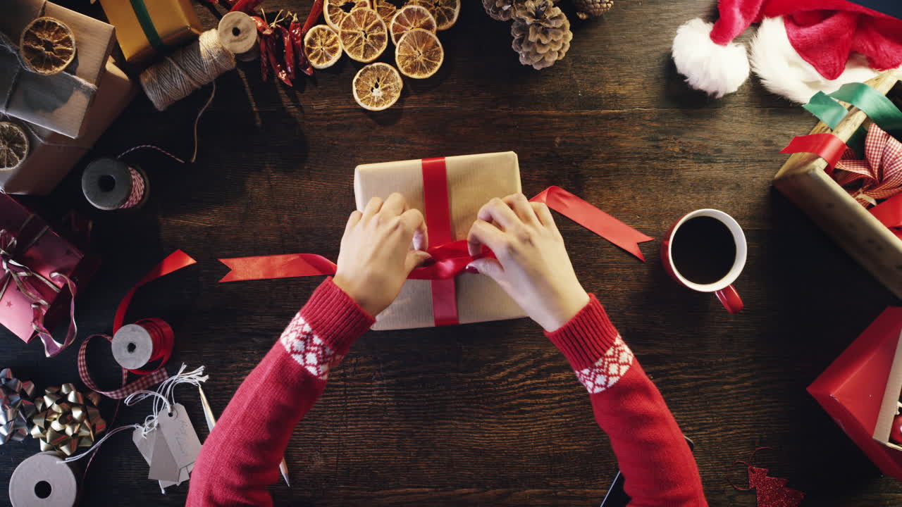 vista superior mujer envolviendo regalos de navidad en manos de escritorio de madera desde arriba - dragón épico rojo