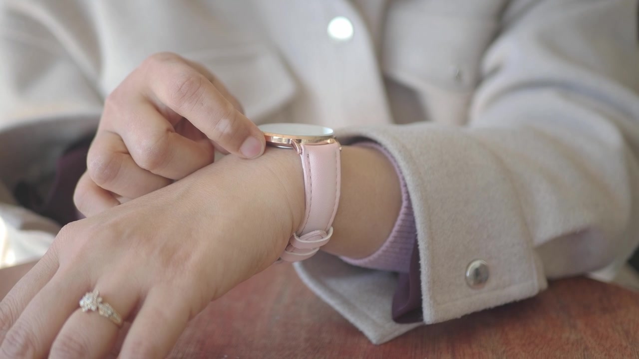 Mano di donna con uno smartwatch rosa