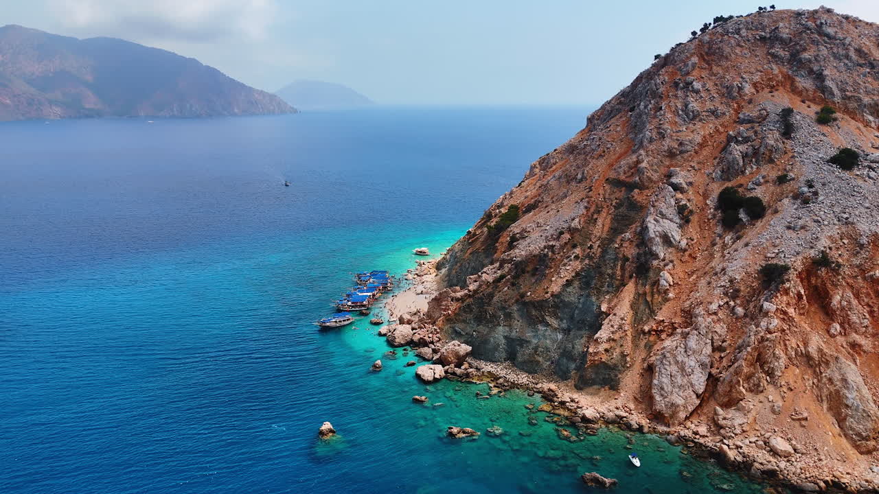 Approaching the row of boats standing on anchor near the rocks. View on the Suluada island in the Turkey Mediterranean