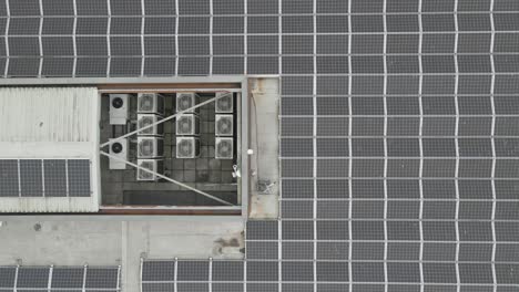 Top-Down-View-Of-Solar-Panels-On-The-Roof-Of-A-Modern-Building-In-Park-West-Business-Park,-Dublin,-Ireland---aerial-drone-shot