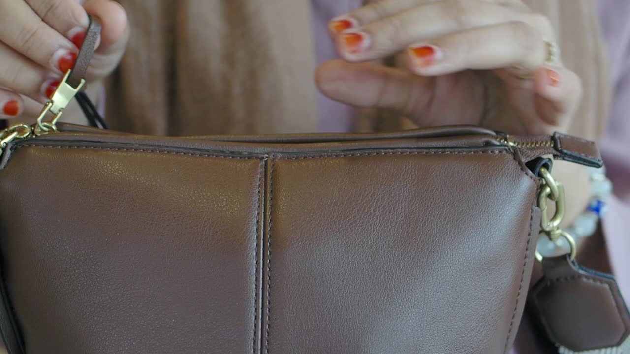 Primo piano di una borsa in pelle marrone con cerniera dorata