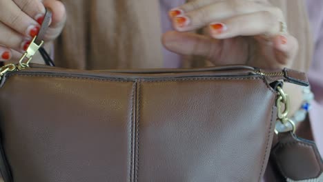 closeup of a brown leather handbag with a gold zipper