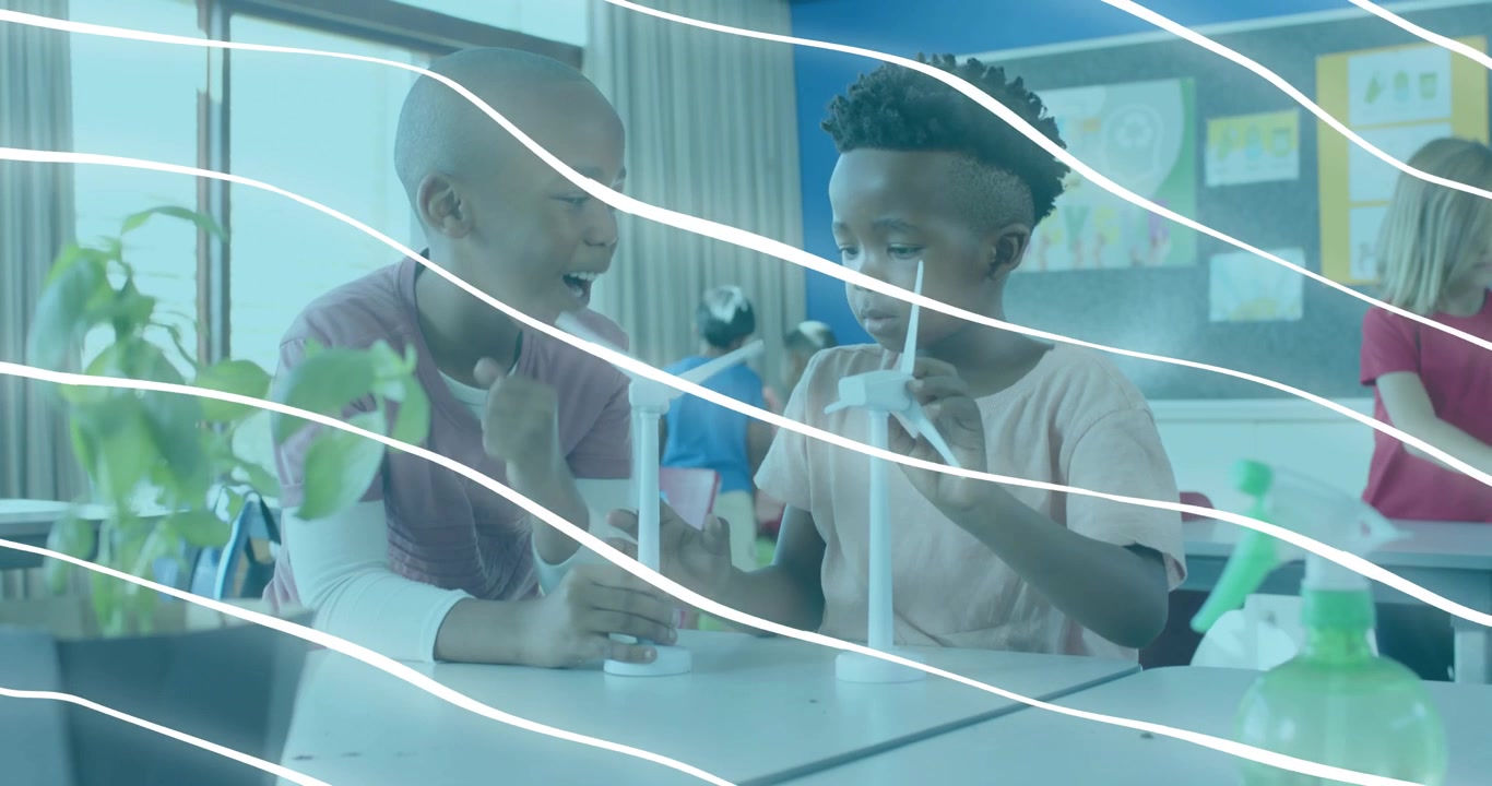 Two boys holding blade upright initiating STEM wind turbine test observing balance and rotation