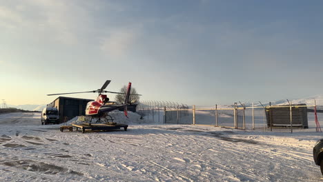 helicopter starting the engine and warming up before take off during a cold snowy winter day, static shot