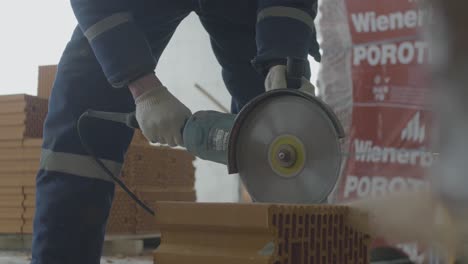 Worker cutting brick with a circular saw