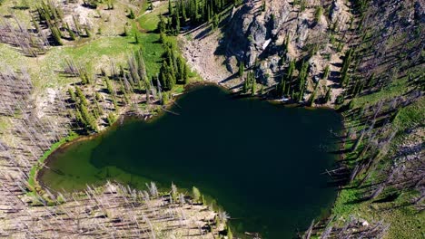 drone aerial shot pulls out and pans up on a backcountry backpacking lake