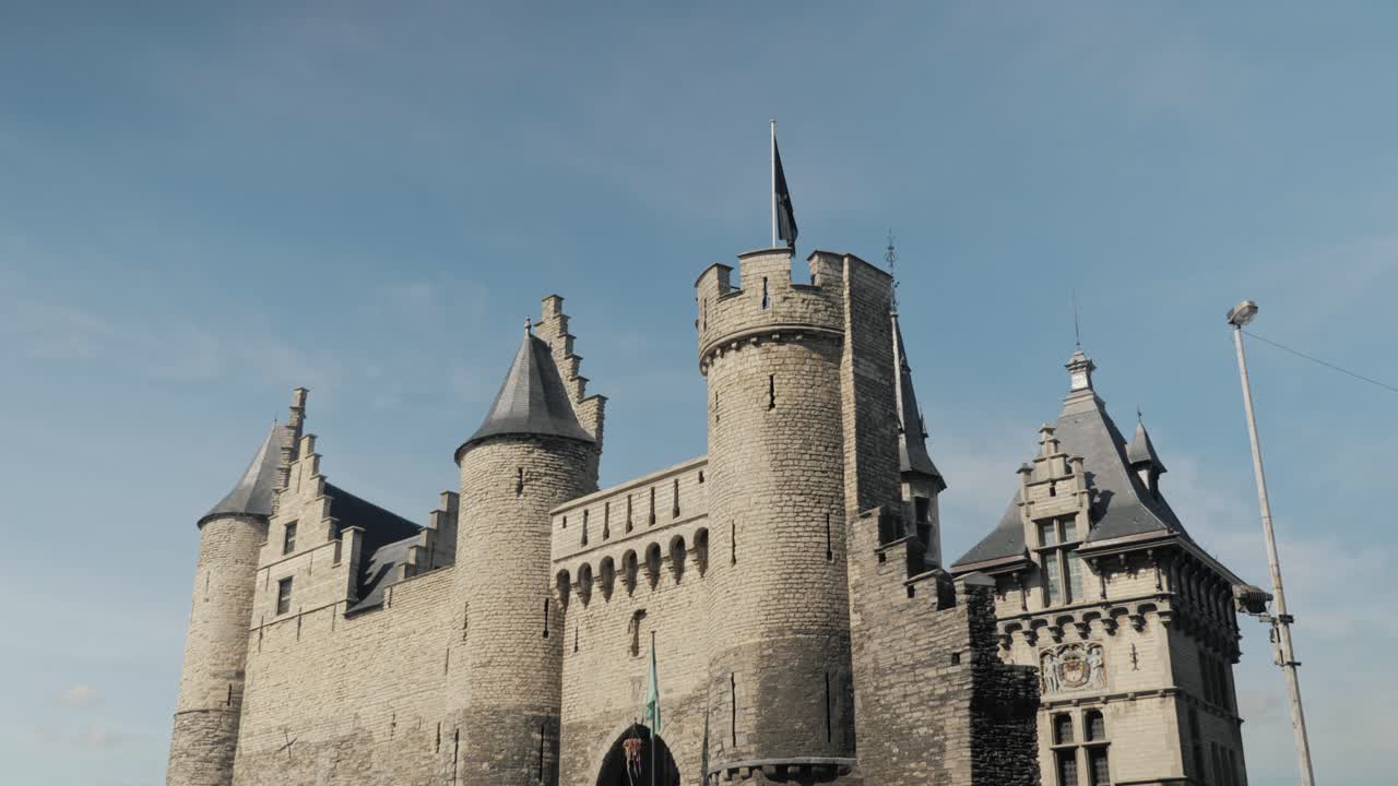 Historic Het Steen castle in Antwerp, Belgium, framed by tree branches, showcasing its medieval architecture
