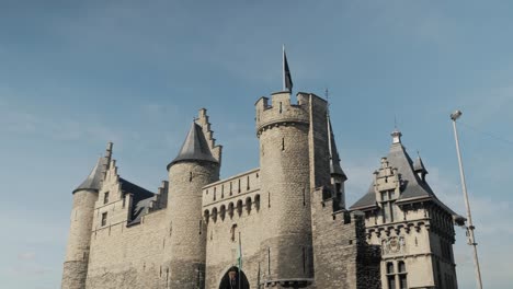 historic het steen castle in antwerp, belgium, framed by tree branches, showcasing its medieval architecture