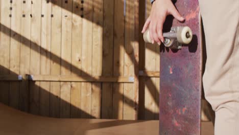 video of midsection of caucasian female skateboarder training in skate park