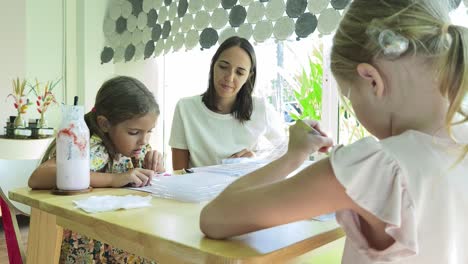 mother and daughters beading together