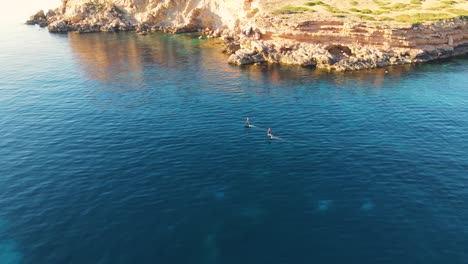 Vista-Aérea-De-Dos-Personas-Navegando-Por-Las-Aguas-De-La-Costa-De-Cala-Escondida-En-Wakeboards-Eléctricos